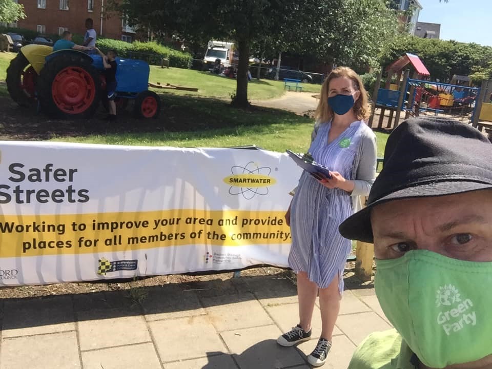 Lucy and Ben in masks by a safer streets banner