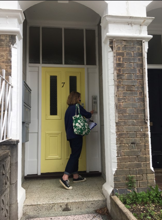 Lucy knocking on a yellow door