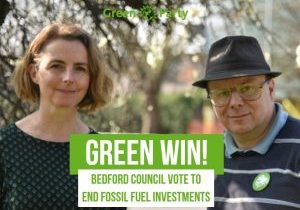 Bedford Borough Councillors Lucy & Ben With Green Party Logo and the words Green Win Bedford Council vote to end fossil fuel investments